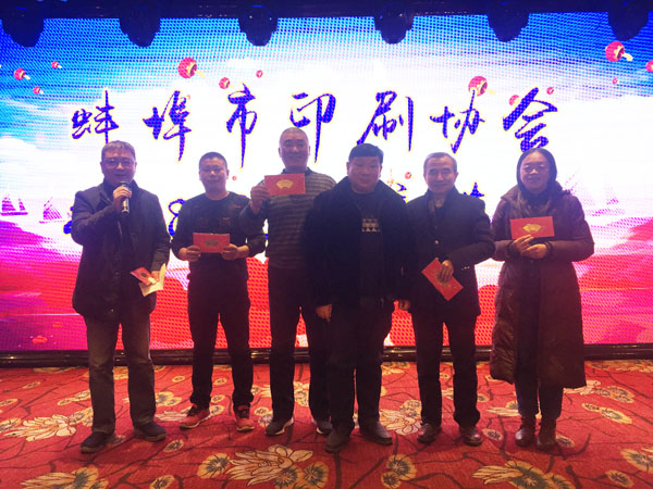 蚌埠市印刷協會副會長、蚌埠市興順彩印廠總經理周興平（中）登臺抽獎，并與獲獎人員合影留念